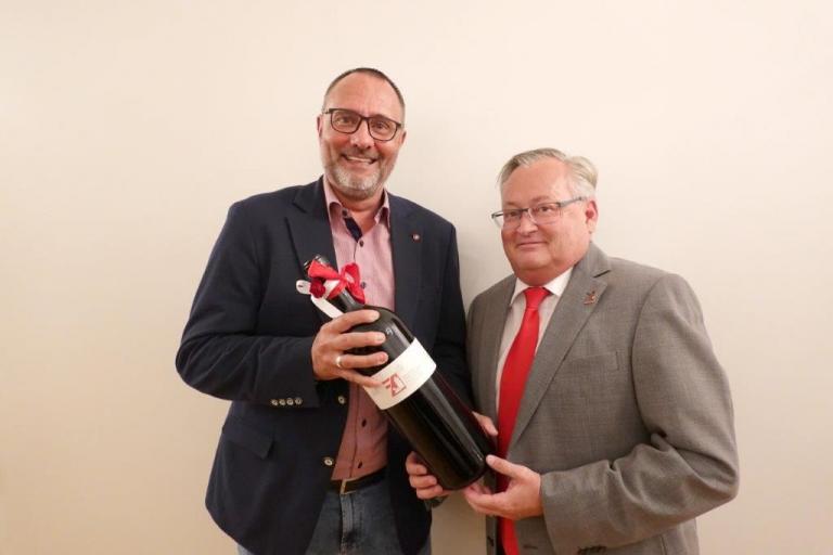 Präsident Marc Nyveler überreicht Martin Zehnder die Magnum-Weinflasche